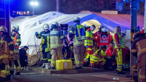 Getty Images Firefighters and emergency responders set up triage units near the Christmas market in Magdeburg