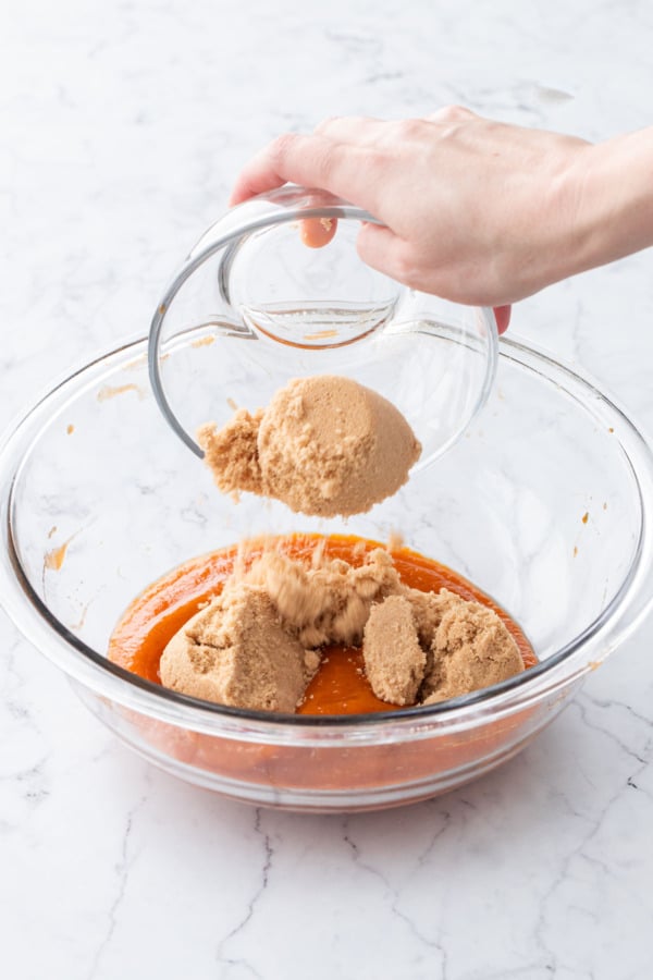 Adding brown sugar to cooled persimmon puree.