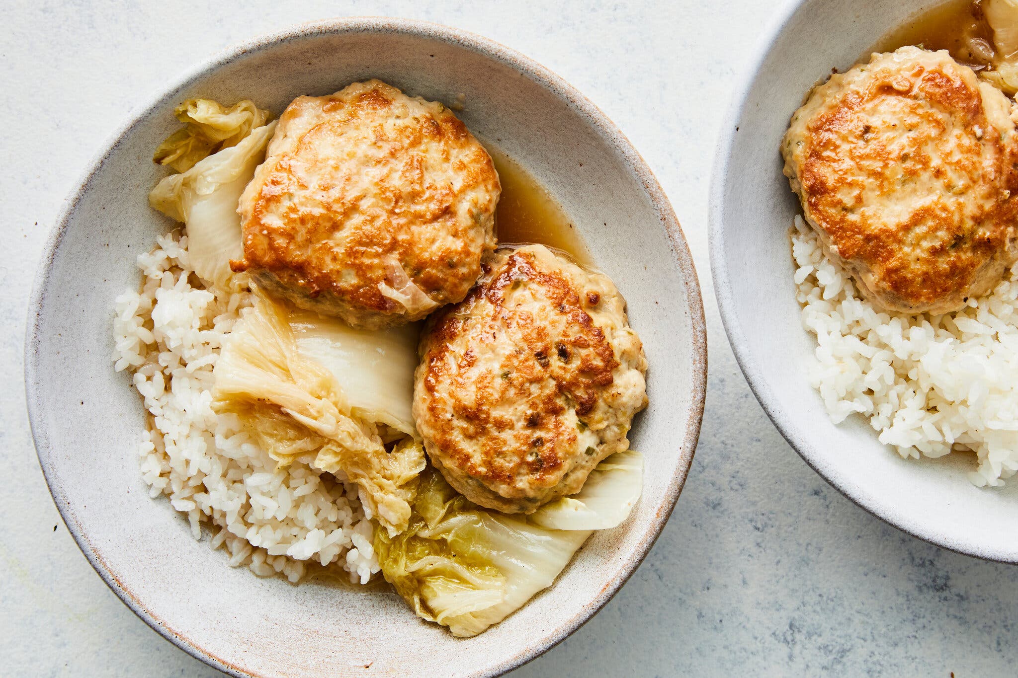 An overhead image of lion’s head meatballs with cabbage and rice.