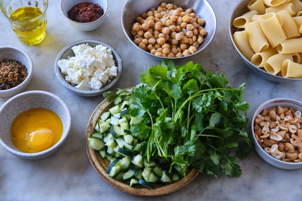 Ingredients to make spicy chickpea pasta bowls on a kitchen counter