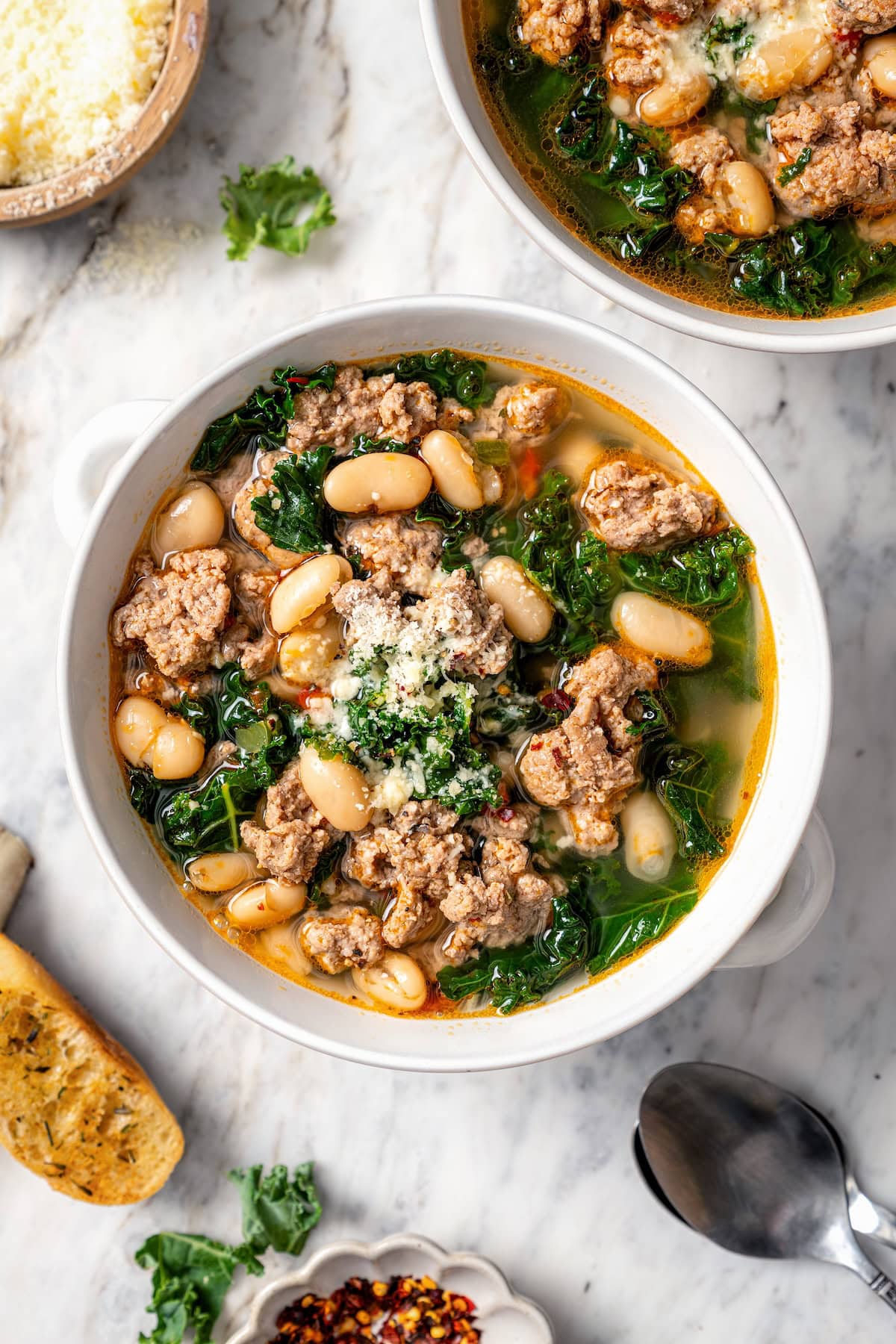 Bowl of white bean soup with sausage and kale.